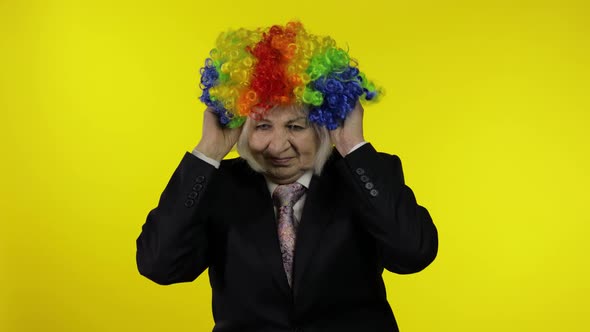 Senior Female Woman in Business Suit Wears Clown Wig, Begin Working and Smiling alt