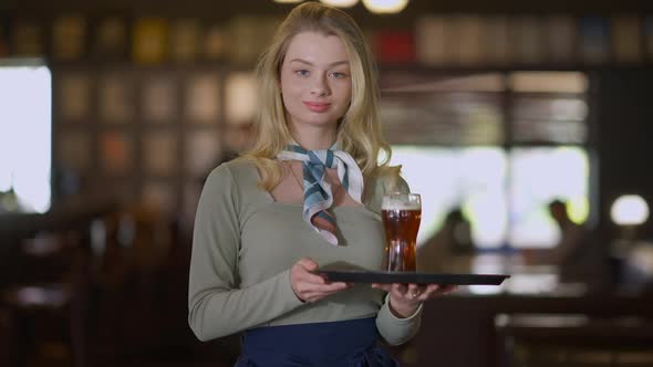Confident Caucasian Smiling Woman Posing with Beer Glass on Tray in Pub alt
