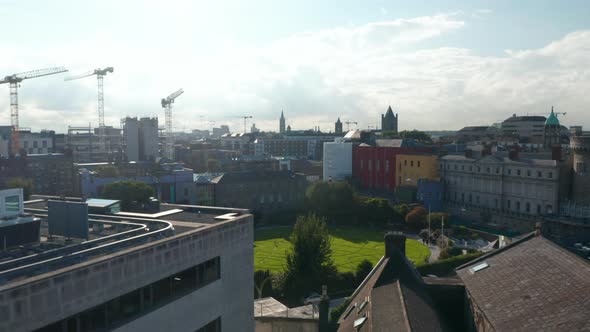 Rising Shot of Town Development and Group of Tower Cranes on Construction Site in Background alt