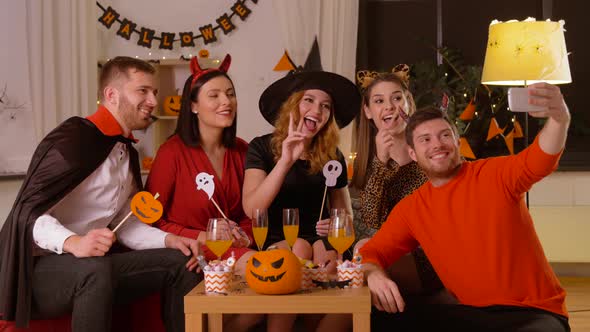 Happy Friends in Halloween Costumes Taking Selfie alt