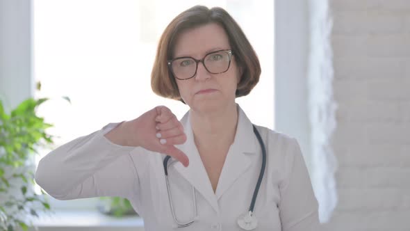 Senior Female Doctor Showing Thumbs Down Gesture alt