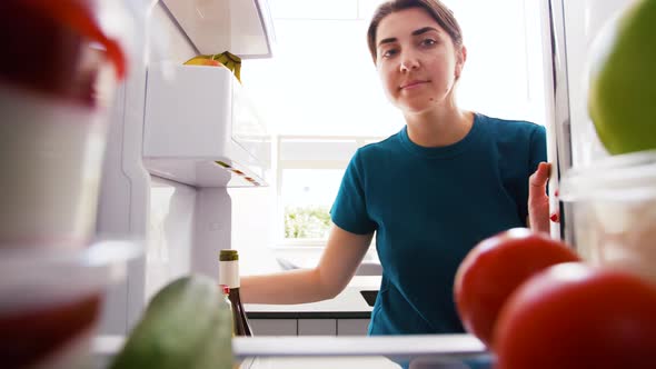 Woman Taking Apple From Fridge at Home Kitchen alt