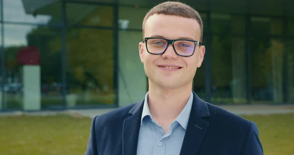 The Businessman Is Looking at the Camera and Smiling alt