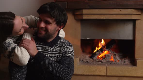 Young Romantic Couple Sitting in Front of Fireplace at Home alt