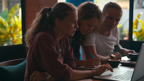 Team of Young Coworkers Working on Laptops and Discussing Business alt