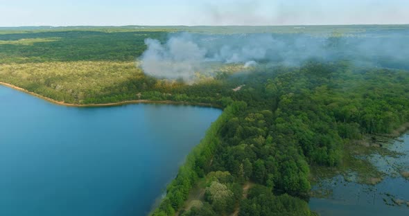 Large Smoke From Forest Fires of Wildfire is Burning Trees Dry Grass Near Lake alt