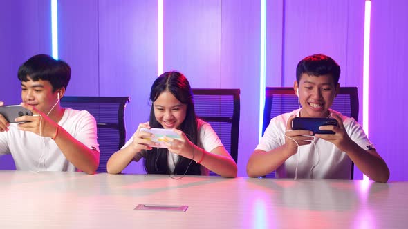 Team Of Asian Gamers Playing In Competitive Video Games On A Cyber Games Tournament By Mobile Phone alt