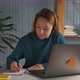Student Girl Sit at Desk Wear Headphones Look at Pc Screen Noting in Exercise Book - VideoHive Item for Sale