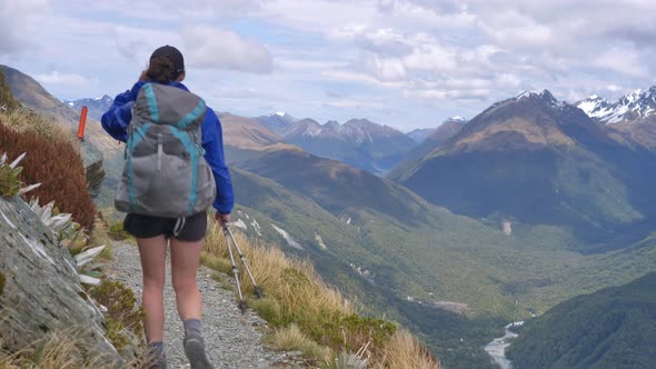 Static, hiker walks exposed windy alpine track, distant valleys, Routeburn Track New Zealand alt