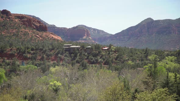 Pan right view of buttes, houses, and trees alt