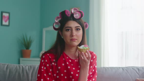 Portrait of Woman with Curlers on Head Eating Cake alt