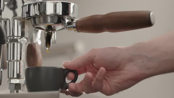 Slow Motion Espresso Pour From Single Spout Portafilter Into Black Cup alt