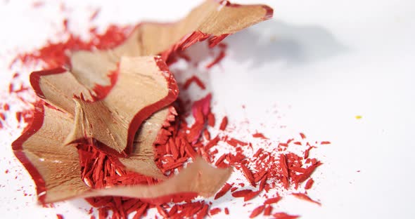 Red color pencils shavings on a white background alt
