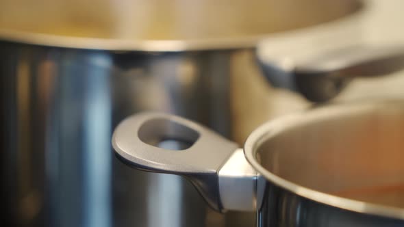Cooking in the Kitchen Steaming Pans on Electric Stove Top Closeup alt