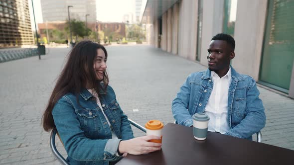 Cheerful Multiethnic Couple Drinking Coffee in City alt