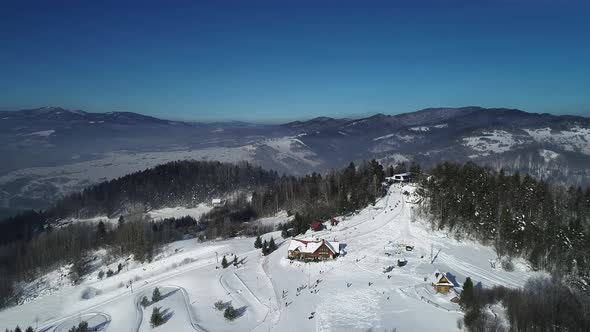 Aerial view of ski resort in mountains during winter season. 