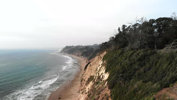 Aerial drone shot over the blue pacific ocean off the coast cliffs on the Santa Barbara, California alt