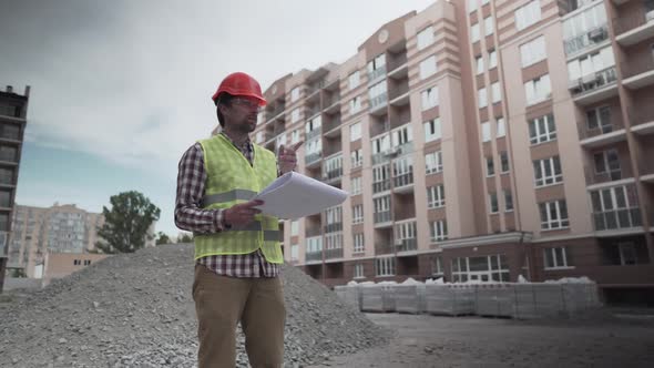 Male Builder Considers Brought Building Material at Construction Site Controls Materials alt