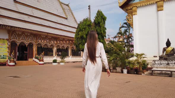 Beautiful woman traveler walking in Buddhist Wat Luang Temple, Pakse, Laos. 4K Slow. Asian culture