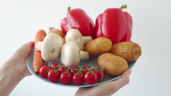 Composition of Vegetables Cherry Tomatoes Peppers Mushrooms and Potatoes in a Woman's Hands