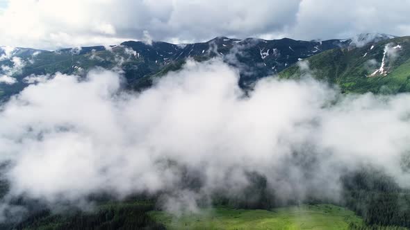 Flying Through the Clouds Above Mountain Tops. High Peaks with Forest, Wonderful Natural Landscape alt