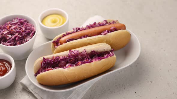 Two hot dog buns with sauerkraut and sausage