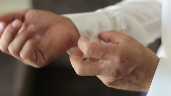 Businessman Buttoning Buttons on Shirt Sleeves alt