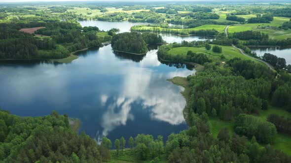 AERIAL: Reflection of Sky on the Surface on Lake near Little Islands Filled with Trees