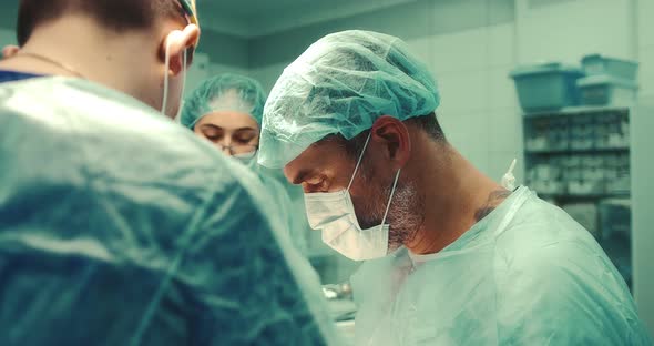 Surgeon Performs the Surgical Operation Together with a Team of Doctors