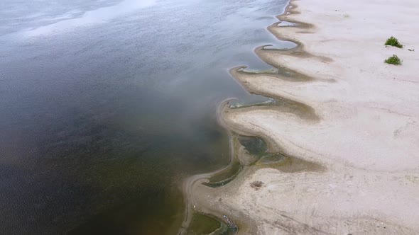 A small bays of the river of unusual shape. Sandy river coast, ripples on the water alt