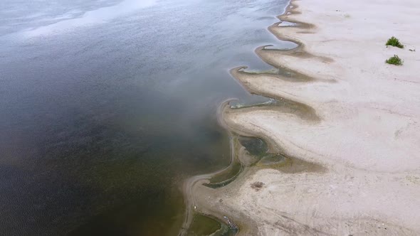 A small bays of the river of unusual shape. Sandy river coast, ripples on the water
