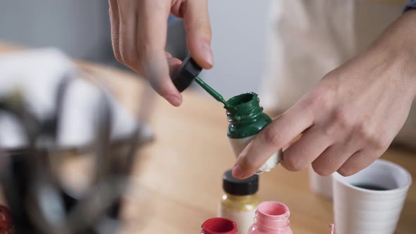 Artist Preparing for Work By Opening Paint Pots in Studio