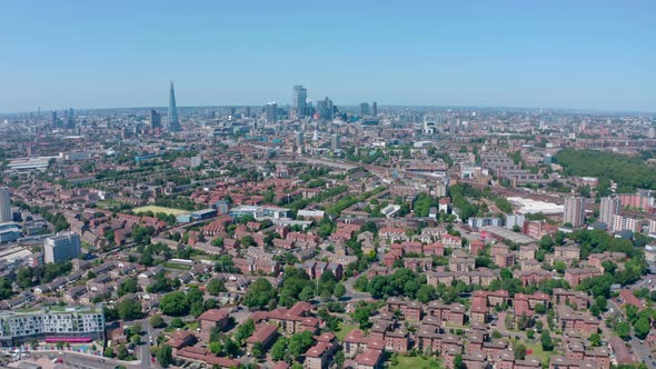 Dolly back drone shot of City of London skyscrapers from residential Southwark alt
