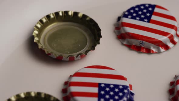 Rotating shot of bottle caps with the American flag printed on them alt
