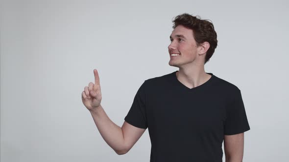 Curly Handsome Model in a Black T-shirt Pointing Up alt