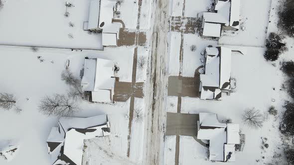 Top down view over rural residential neighborhood in winter. Everything is snow covered.