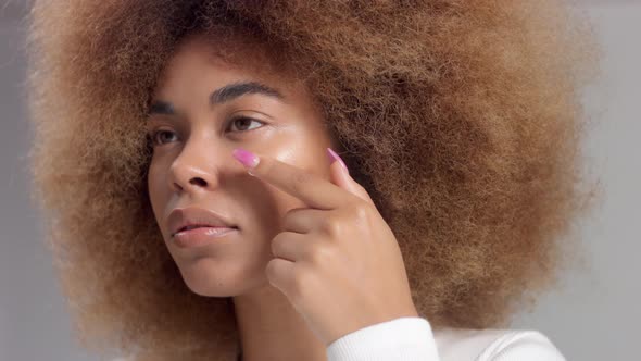 Mixed Race Black Woman with Big Afro Hair in Studio Put a Cream Smudge alt