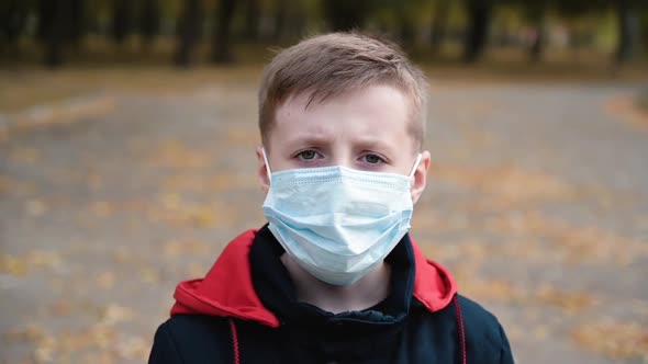 Portrait of Little Boy Wearing Medical Mask on Street in City