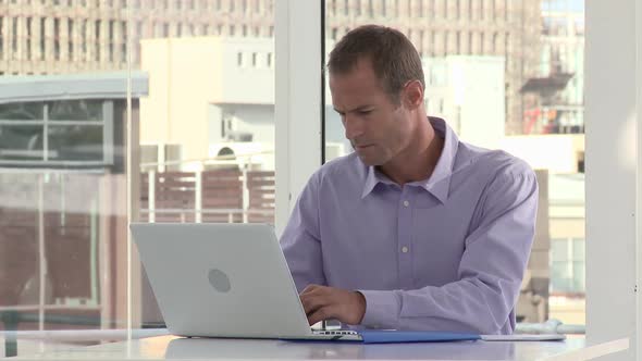 Businessman using laptop in office alt