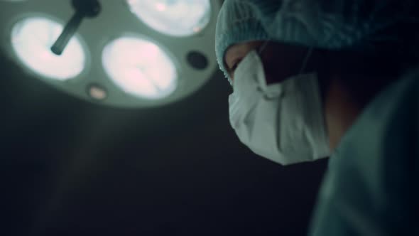 Portrait Nurse Performing Operation Holding Medical Clamp in Operating Room alt