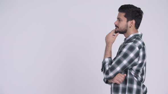Profile View of Young Happy Bearded Indian Man Thinking alt