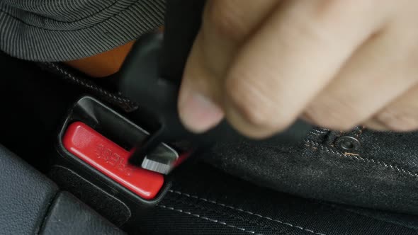 Driver connects 3-point seat  belt on car bracket 4K video alt