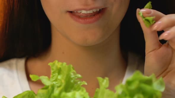 Woman Eating Fresh Lettuce and Smiling, Vegetarian Diet, Avoiding Meat Meals alt