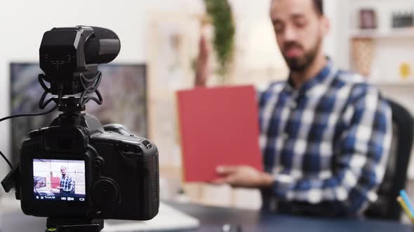 Creative Young Man Recording a Book Review alt