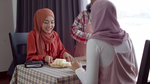 Senior waitress woman serve coffee to two muslim women alt