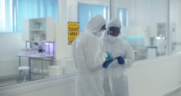 Scientists in Ppe Suit During Coronavirus Outbreak Working in Laboratory Using Tablet Pc alt