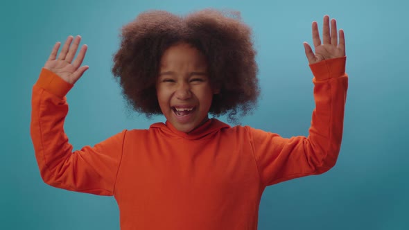 Cheerful African American girl raising her hands up as triumph alt