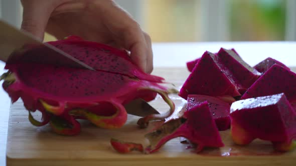 Chef cuts into pieces the tropical fruit pitahaya or dragon fruit, Thailand alt