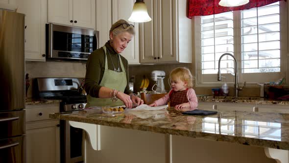 Loving grandmother and granddaughter count the chocolate as they start to make cookies in the kitche alt