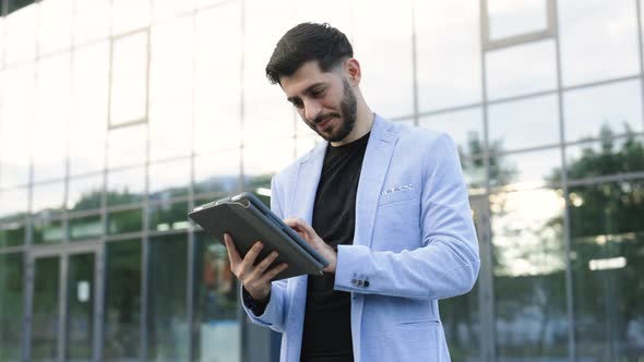 Man Engaged in Business Using Tablet Computer Reading Financial News Online